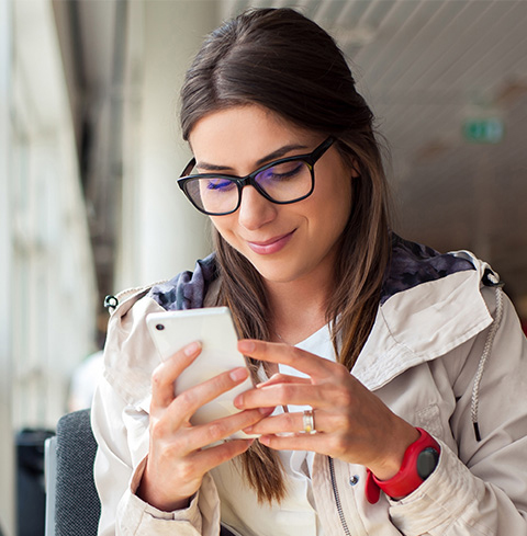 Une femme à lunettes tenant un téléphone mobile Une femme à lunettes tenant un téléphone mobile