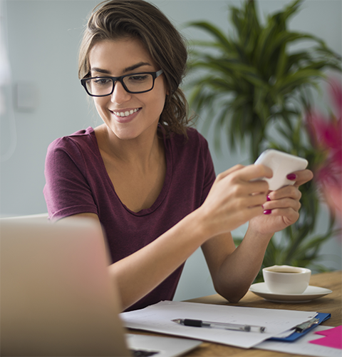 Une femme à lunettes travaille à un bureau.